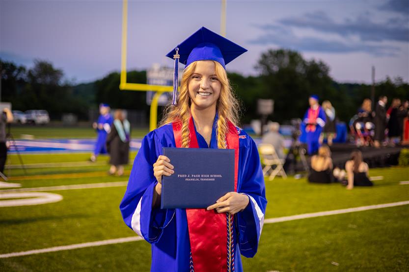 Students in blue robes graduate